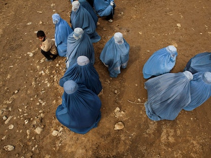 نساء أفغانيات ينتظرن دورهن في مركز توزيع تابع لبرنامج الغذاء العالمي في كابول. 10 فبراير 2011. - REUTERS