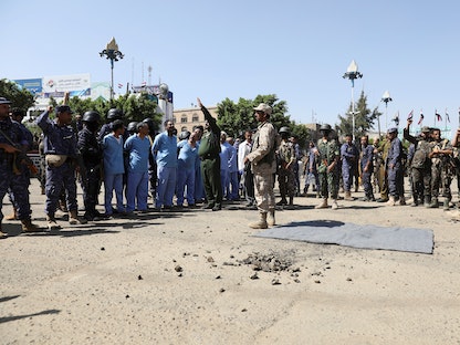 جنود من جماعة الحوثي يقفون بجانب رجال يتهمونهم بالتورط في مقتل القيادي الحوثي صالح الصماد في 2018 قبل إعدامهم في ساحة التحرير بصنعاء ، اليمن - 18 سبتمبر 2021 - REUTERS