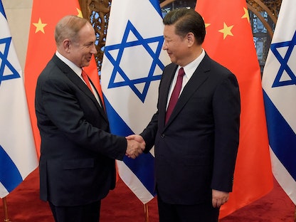 الرئيس الصيني شي جين بينج ورئيس الوزراء الإسرائيلي السابق بنيامين نتنياهو يتصافحان قبل محادثاتهما في بكين، 21 مارس 2017  - AFP
