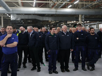 عمال يستمعون إلى خطب خلال حدث صحافي في مصنع فورد هالوود للإرسال في ليفربول ببريطانيا في 1 ديسمبر 2022. - REUTERS