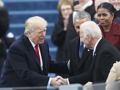 جو بايدن عندما كان نائباً للرئيس السابق باراك أوباما يصافح الرئيس المنتخب دونالد ترمب خلال مراسم التنصيب في مبنى الكابيتول- 20 يناير 2017 - REUTERS