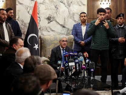 فتحي باشاغا رئيس الحكومة الليبية المعينة من البرلمان (في الوسط) يلقي خطاباً في مطار معيتيقة الدولي، طرابلس، ليبيا. 10 فبراير 2022. - REUTERS