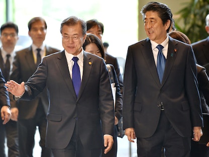 رئيس الوزراء الياباني السابق شينزو آبي (يمين) والرئيس الكوري الجنوبي السابق مون جاي إن خلال قمة في طوكيو - 9 مايو 2018 - Bloomberg