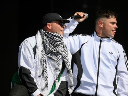أحد أعضاء فريق Kneecap الإيرلندي يرتدي الكوفية الفلسطينية بمهرجان جلاستونبيري، سومرسيت، بريطانيا. 28 يونيو 2025 - REUTERS