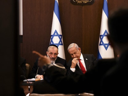 رئيس الوزراء الإسرائيلي بنيامين نتنياهو يتحدث مع وزير الداخلية أرييه درعي خلال الاجتماع الأسبوعي للحكومة في القدس. 8 يناير 2023 - AFP