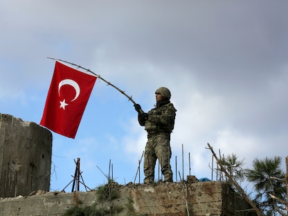 جندي تركي يرفع علم بلاده في شمال شرق عفرين السورية - 28 يناير 2018 - REUTERS