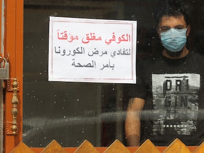 لافتة على أحد المقاهي في بغداد تفيد بأنه مغلق لمنع انتشار فيروس كورونا - AFP