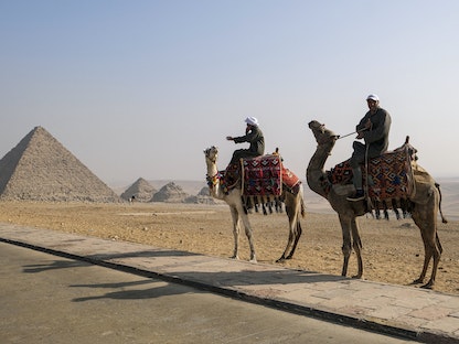 مدرّبو جمال ينتظرون السياح قرب هرم منقرع في مقبرة أهرامات الجيزة في مصر- 7 يناير 2021 - AFP