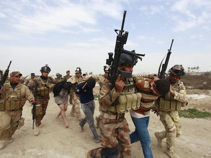 عناصر من قوات الأمن العراقية يعتقلون مسلحين مشتبه بهم من تنظيم داعش جنوب بغداد، 15 فبراير 2014  - REUTERS