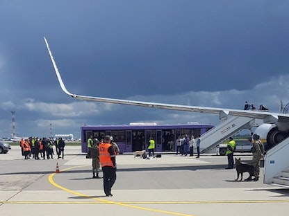 موظفون أمام طائرة "راين إير" التي أُرغمت على الهبوط في بيلاروسيا، 23 مايو 2021 - REUTERS