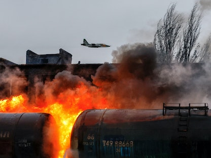 مقاتلة روسية تحلق فوق تقاطع للسكك الحديد مشتعلة في بلدة شاختارسك (شاختيارسك) بالقرب من دونيتسك- 26 أكتوبر 2022 - REUTERS