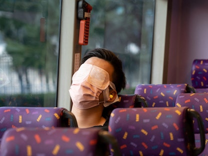 مسافر نائم في حافلة بهونج كونج. 14 نوفمبر 2021 - AFP