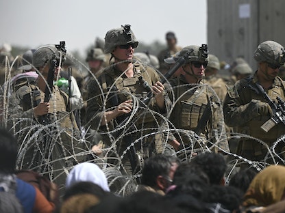جنود أميركيون أمام حاجز من السلك الشائك وسط عمليات الإجلاء من مطار العاصمة الأفغانية كابول، 20 أغسطس 2021  - AFP