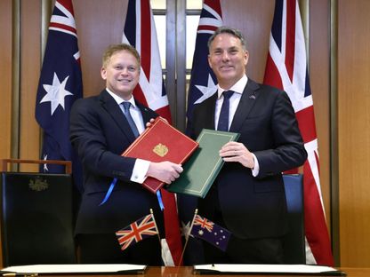وزير الدفاع الأسترالي ريتشارد مارليس (يمين) ونظيره البريطاني جرانت شابس خلال مراسم توقيع الاتفاقية في البرلمان بالعاصمة كانبرا. 21 مارس 2024 - AFP