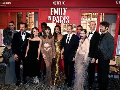 فريق مسلسل "إيميلي إن باريس" رفقة المخرج الأميركي دارين ستار  على السجادة الحمراء قبل العرض العالمي الأول للموسم الثالث في مسرح الشانزليزيه بالعاصمة الفرنسية. 6 ديسمبر 2022  - AFP