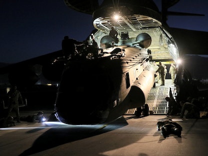 تحميل هليكوبتر من طراز CH-47 Chinook في طائرة تابعة للقوات الجوية الأميركية ضمن خطة الانسحاب من أفغانستان - 16 يونيو 2021 - REUTERS