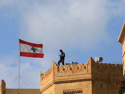 جندي بالجيش اللبناني يقف فوق بناية إلى جانب علم لبنان خلال الانتخابات الرئاسية في البرلمان وسط العاصمة بيروت-31 أكتوبر 2016 - REUTERS
