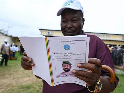 مواطن في مالي يقرأ مسودة دستور البلاد والتي سيتم تقديمها إلى استفتاء 18 يونيو- 11 يونيو 2023. - AFP