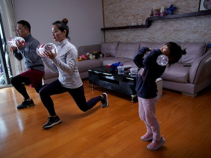 عائلة صينية تمارس تدريبات اللياقة البدنية في المنزل خلال فترة عزل كورونا، شنغهاي. 20 فبراير 2020 - REUTERS