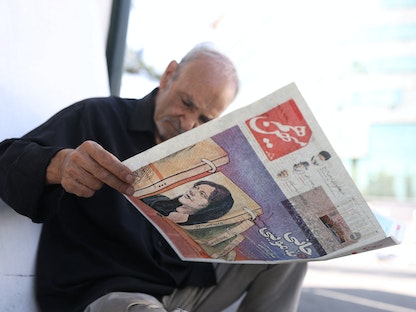 مواطن إيراني يطالع صحيفة في طهران تتصدرها صورة مهسا أميني "ضحية شرطة الأخلاق" - 18 سبتمبر 2022 - REUTERS