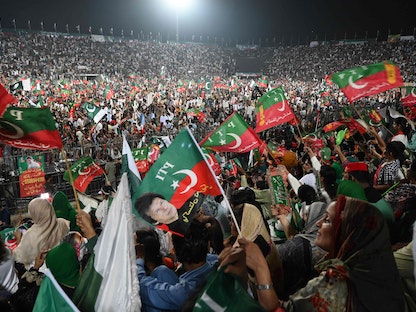 أنصار رئيس الوزراء الباكستاني السابق عمران خان يلوّحون بأعلام خلال تجمّع في لاهور. 13 أغسطس 2022 - AFP