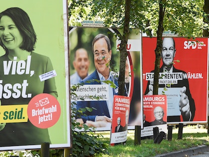 لافتات انتخابية في مدينة هامبورغ تظهر أبرز المرشحين لمنصب المستشار الألماني: أولاف شولتز من الحزب الاشتراكي الديمقراطي (يمين)، أرمين لاشيت زعيم "الاتحاد الديمقراطي المسيحي"(وسط)، ونالينا بربوك مرشحة حزب "الخضر"- 31 أغسطس 2021 - REUTERS