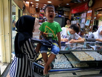 طفل رفقة والدته يصرخ في متجر مجوهرات في جاكرتا بإندونيسيا. 12 ديسمبر  2017 - REUTERS