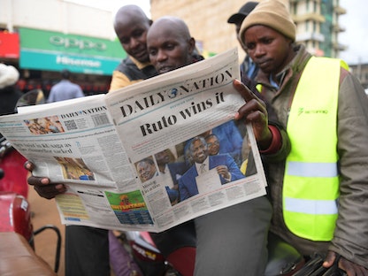 كينيون في العاصمة نيروبي يقرأون صحيفة تعلن فوز وليام روتو بانتخابات الرئاسة. 16 أغسطس 2022 - AFP