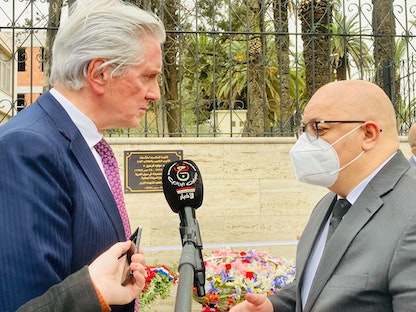وزير المجاهدين وذوي الحقوق الجزائري العيد ربيقة، وسفير فرنسا لدى الجزائر فرنسوا جوييت، يضعان أكاليل الزهور أمام لوحة تذكارية تخلد اغتيال الكاتب الجزائري الشهير مولود فرعون، الجزائر - 15 مارس 2022. - Twitter@ambafrancealger