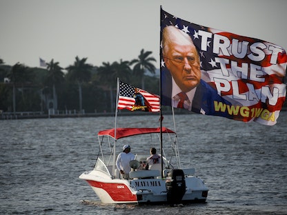 أنصار الرئيس الأميركي السابق دونالد ترمب يرفعون صورته على قارب في بحيرة وورث لاجون في فلوريدا، الولايات المتحدة. 18 مارس 2023 - REUTERS