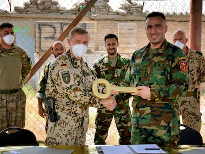 الجنرال الألماني ماير (يسار) والمقدم الأفغاني عميد ألميار خلال مراسم تسليم معسكر مايك سبان إلى القوات الأفغانية في مزار الشريف - 5 مايو 2021 - REUTERS