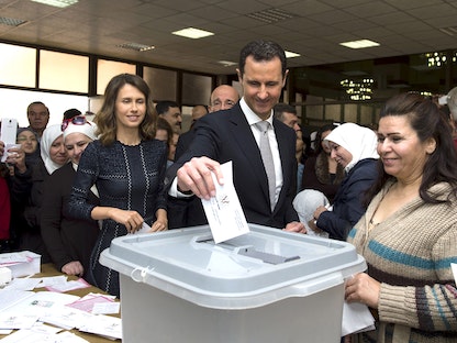 الرئيس السوري بشار الأسد يدلي بصوته وبجانبه زوجته أسماء، داخل مركز اقتراع خلال الانتخابات البرلمانية في دمشق- 13 أبريل 2016 - REUTERS