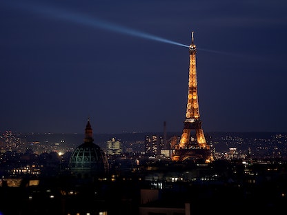 برج إيفل في العاصمة الفرنسية باريس أثناء إضاءته ليلاً بأنوار خافتة - 9 مارس 2022 - REUTERS