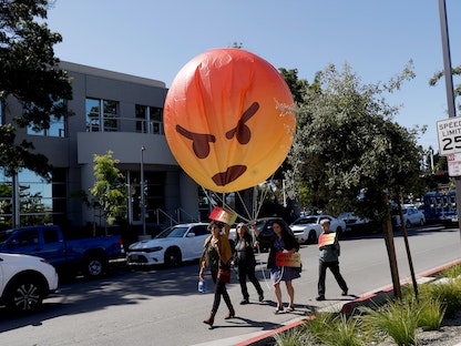 متظاهرون يحملون "إيموجي" خلال احتجاجات في كاليفورنيا - 30 مايو 2019 - REUTERS