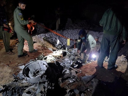 عناصر الجيش الباكستاني يفحصون بقايا الصاروح الهندي الذي وقع في منطقة ميان تشانو في باكستان. 9 مارس 2022. - REUTERS