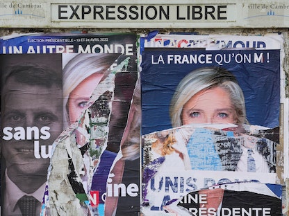 ملصق للمرشحين للرئاسة الفرنسية إمانويل ماكرون ومارين لوبان - 15 أبريل 2022 - REUTERS
