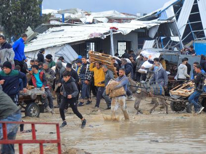 نازحون فلسطينيون يتكدسون وسط برك من المياه في مدينة غزة. 27 يناير 2024 - Reuters