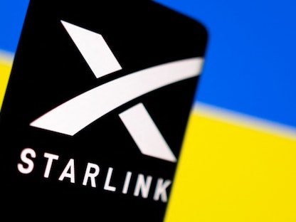 شعار خدمة "ستارلينك" وفي الخلفية علم أوكرانيا - REUTERS