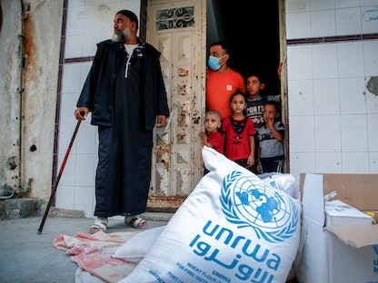 عائلة فلسطينية تتلقى مساعدات تقدمها وكالة أونروا في قطاع غزة، 15 سبتمبر 2020 - AFP