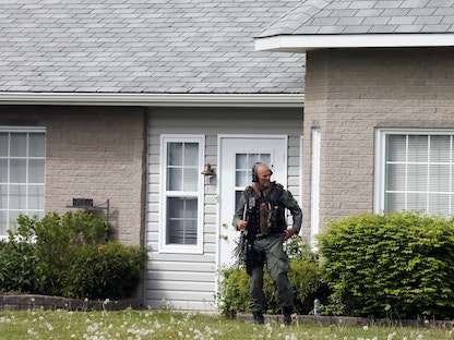 ضابط شرطة يحرس منزلاً في حي مونكتون السكني بكندا بعد حادثة إطلاق نار - 5 يونيو 2014 - REUTERS