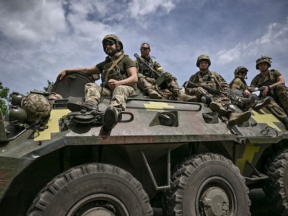 جنود أوكرانيون يجلسون على عربة مدرعة أثناء عودتها من خط المواجهة قرب مدينة سلوفيانسك في منطقة دونباس بشرق أوكرانيا - 1 يونيو 2022 - AFP