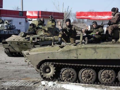 مقاتلون من الانفصاليين الموالين لروسيا في دونباس يركبون وحدات مدفعية متحركة في بلدة ديبالتسيف - 22 فبراير 2015 - REUTERS
