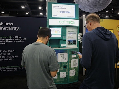 أشخاص يشترون عملات البيتكوين من ماكينة الصراف الآلي Coinstar خلال مؤتمر Bitcoin 2022 في مركز مؤتمرات ميامي بيتش بولاية فلوريدا الأميركية - 8 أبريل 2022 - AFP