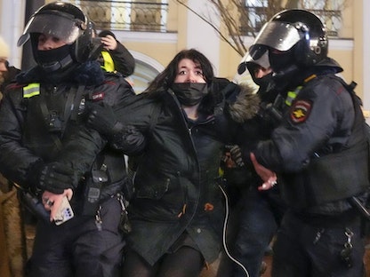 فردان من الشرطة الروسية يعتقلان امرأة خلال المظاهرات المناهضة لغزو أوكرانيا في سان بطرسبرج. 25 فبراير 2022 - AP