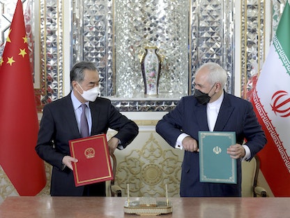 وزير الخارجية الإيراني محمد جواد ظريف ونظيره الصيني وانغ يي، خلال توقيع اتفاق التعاون الاستراتيجي في طهران، 27 مارس 2021 - AP