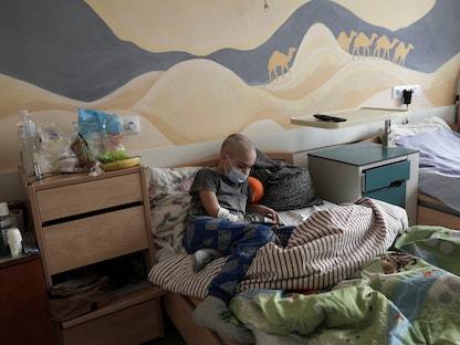 طفل مريض بالسرطان يستلقي على سريره في عيادة الأورام في مركز طب الأطفال المتخصص بعلاج الأورام في لفيف بأوكرانيا - 9 مارس 2022  - REUTERS