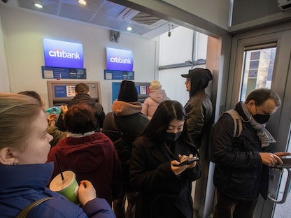 يصطفون أمام ماكينتين للصرف الآلي في فرع لمصرف "سيتي بنك" بموسكو  - 24 فبراير 2022 - Bloomberg