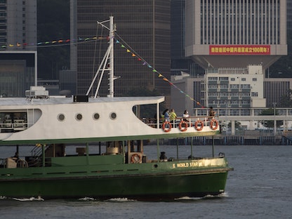 قارب يمرّ أمام مبنى الجيش الصيني في هونغ كونغ - 1 يوليو 2021 - Bloomberg