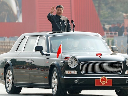 الرئيس الصيني شي جين بينج يلوّح من سيارة خلال عرض عسكري في بكين لمناسبة الذكرى السبعين لتأسيس "جمهورية الصين الشعبية" - 1 أكتوبر 2019 - REUTERS