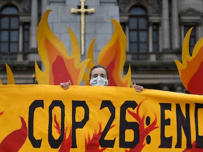 ناشط يحمل لافتة خلال احتجاج قبل مؤتمر الأمم المتحدة لتغير المناخ (كوب 26)، في غلاسكو، إسكتلندا، 28 أكتوبر 2021 - REUTERS
